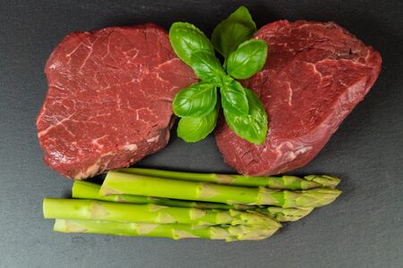 Raw filet steak with spices and vegetablesの写真素材