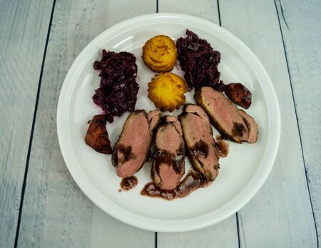 Fried duck breast with red cabbage and croquettesの写真素材