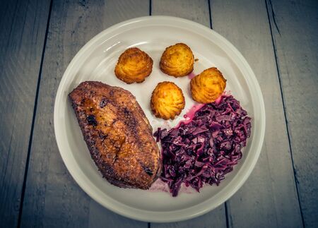 Fried duck breast with red cabbage and croquettesの写真素材