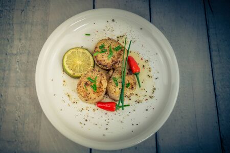 Fried saltwater seashells pectinidae with herbs and spices