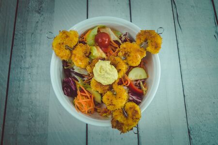 Crispy wrapped and fried Shrimp on a shashlik stick with saladの写真素材