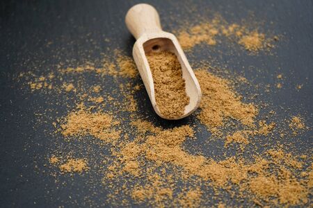 Brown coriander powder and wooden spoonの写真素材