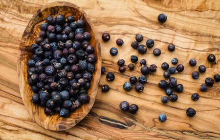 dried juniper berries on olive woodの写真素材
