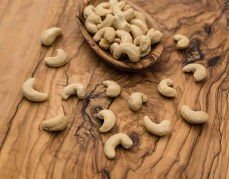 a pile of cashews on olive woodの写真素材