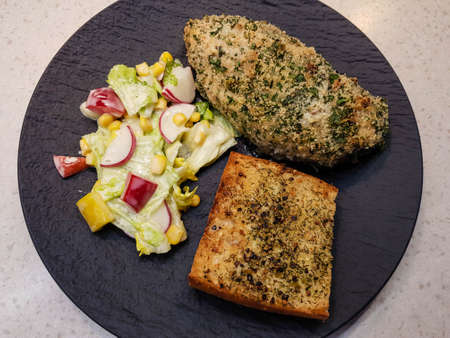 marinated chicken breast with herb crust salad and garlic breadの写真素材