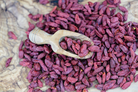 dried goji berries on olive wood