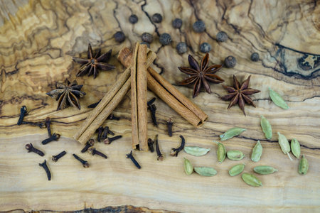 different christmas spices on olive wood