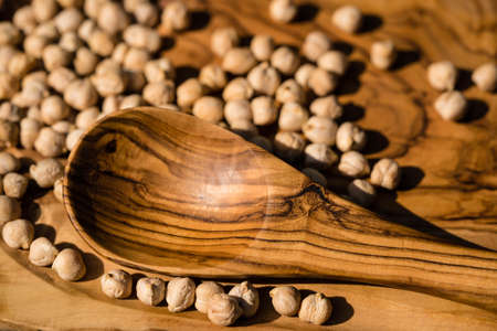 a pile of chick peas and a wooden spoonの写真素材