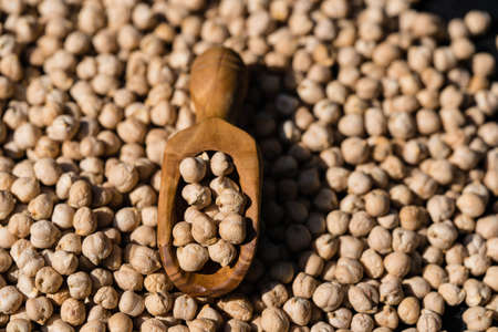 a pile of chick peas and a wooden spoonの写真素材
