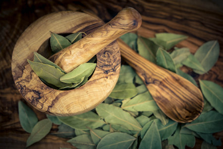 Bay leaves and juniper berries on olive woodの写真素材