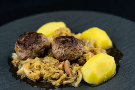 Traditional German meatloafs with savoy cabbage bacon and boiled potatoes