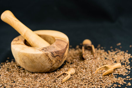 a pile of flaxseeds and utensils made of olive wood
