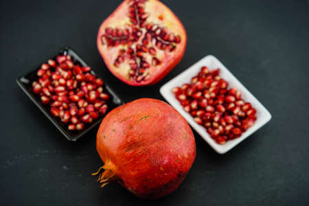 sliced red pomegranate on a slate