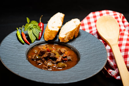 traditional Hungarian food beef goulash with bread and spicy peppersの写真素材