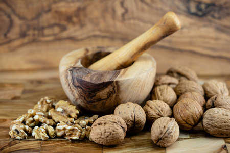 Fresh and cracked walnuts on olive wood