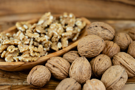 Fresh and cracked walnuts on olive wood