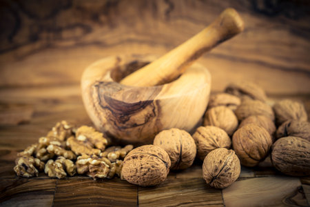 Fresh and cracked walnuts on olive wood