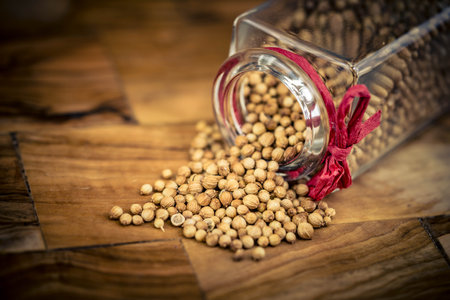 Seeds of coriander Coriandrum sativum on olive woodの写真素材