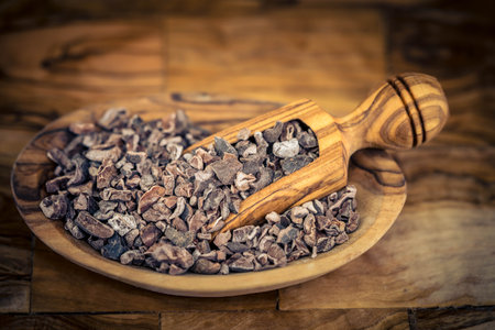 brown chocolate nibs on olive woodの写真素材