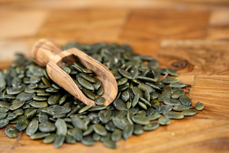 roasted pumpkin seeds on olive woodの写真素材