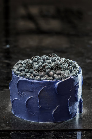 Blueberry cake decorated with fresh berries on a black background. Toned.の写真素材