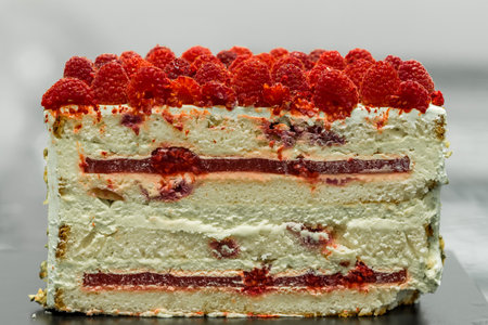 Cake with raspberries on a black background, close-up