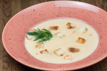 Creamy soup with croutons and dill on a plate