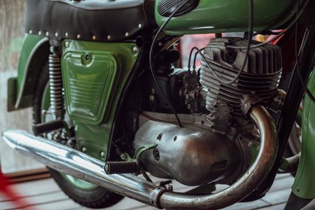 Close-up of a green motorcycle parked on a wooden floor.の写真素材
