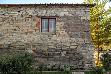 Old stone wall with a window in the village in Ukraineの写真素材