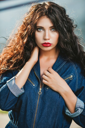 Portrait of a beautiful young brunette woman with long curly hair.の写真素材