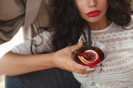 Close-up of a beautiful young woman with a glass of cocktailの写真素材