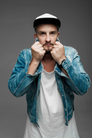 Portrait of a young man in a denim jacket and cap.