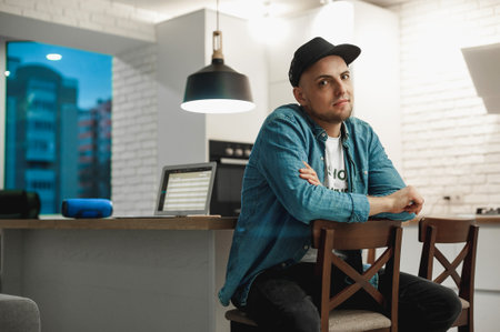 Portrait of a handsome young man in a cap sitting at a table in a cafe
