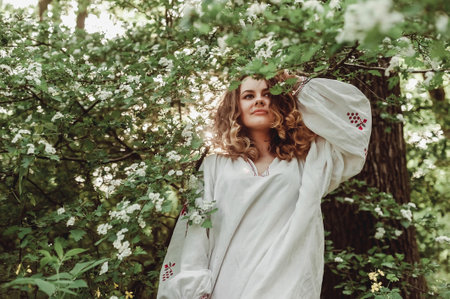 Beautiful girl in a white dress in the spring blooming gardenの写真素材