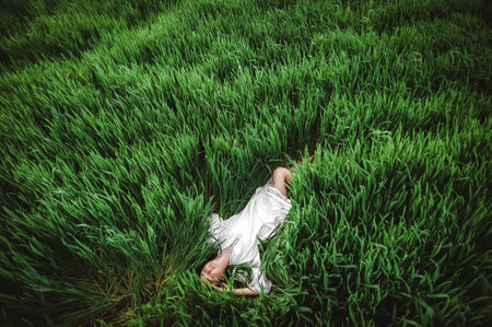 Beautiful girl in a white dress in the field of wheat.の写真素材