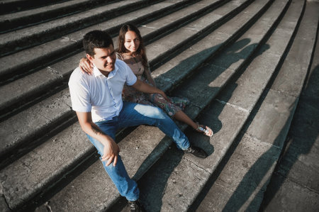 Young couple sitting on the steps of an old building in the city