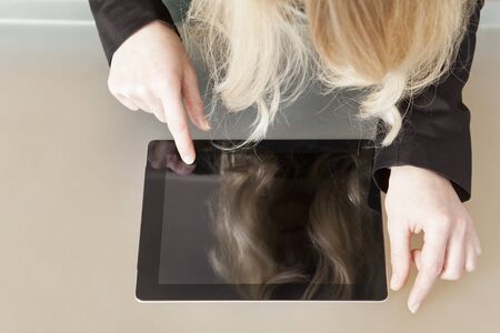 Woman touches with finger the screen of a Tablet PCの写真素材