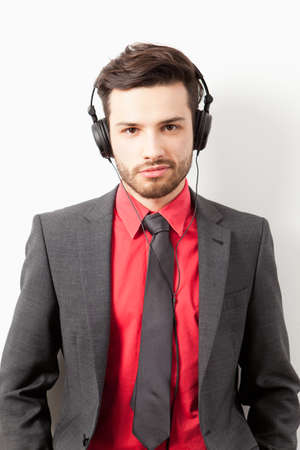 Man in suit listening to music with headphonesの写真素材