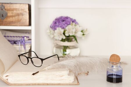 Eyeglasses and fountain pen on a blank page of a hand-bound bookの写真素材