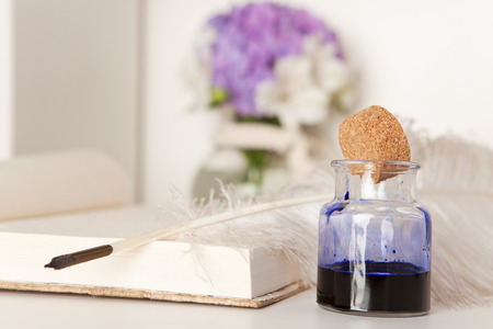 Open book with fountain pen and inkwellの写真素材