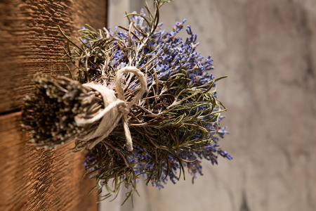 A bouquet of lavender hung out to dry on a rustic wooden wallの写真素材
