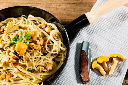 Pasta with chanterelles in a rustic panの写真素材