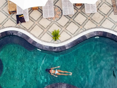a young girl with pleasure swims in the pool.the view from the top..の写真素材