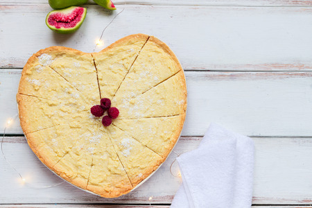 Homemade cookie with raspberry, fig and lights with towel on the white wood deskの写真素材