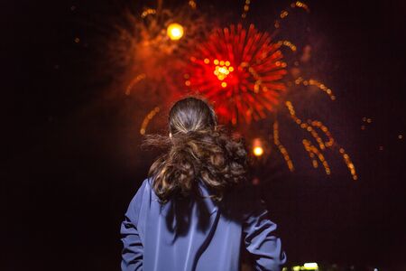 A woman enjoys the fireworks in the sky.Concept of festivals and holidays with fireworks. The view...