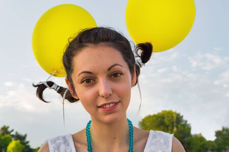 portrait of a girl with tied pigtails to balloons