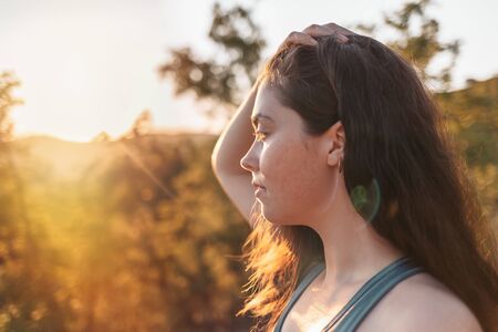 Young sexy athletic woman resting and looking into the distance. Forest in the background. Sports,...