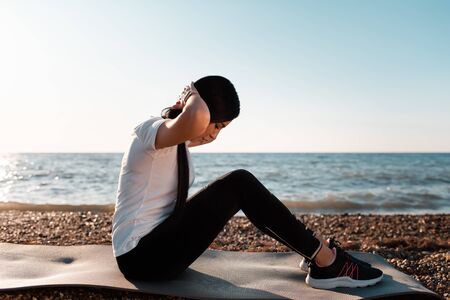Concept of sport and healthy lifestyle. Woman in sportswear is training on the Mat. In the...