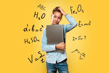 Concept of modern technologies and education. A young Caucasian teenager in a blue shirt, with a...