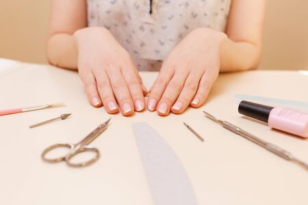 Medicine, cosmetology and manicure. A client in a nail salon demonstrates well-groomed nails after...